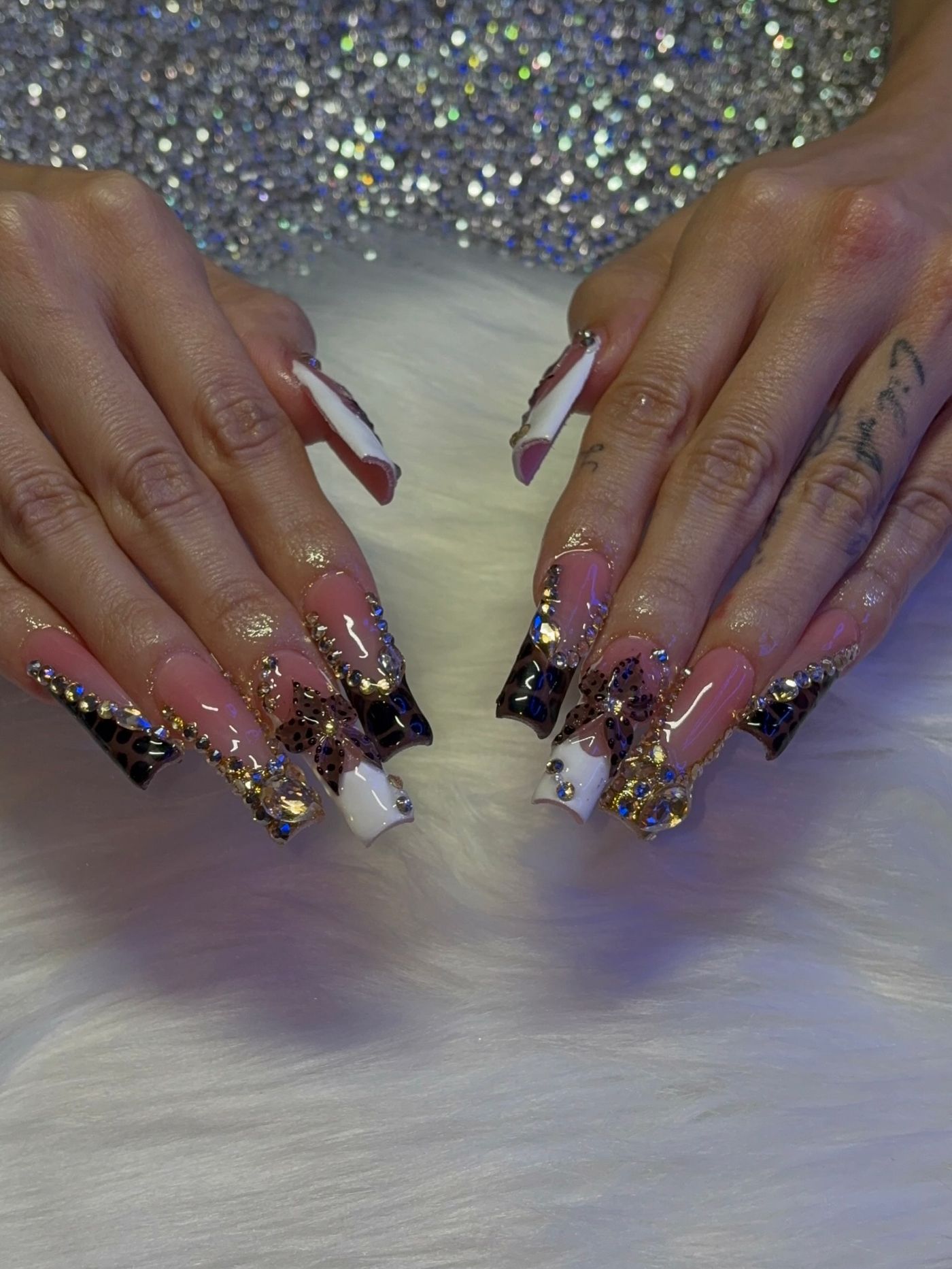 Leopard and gold nails against a wall of crystals on white fur